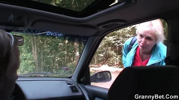 Stort Hitchhiking 70 years old granny riding roadside varmt rør