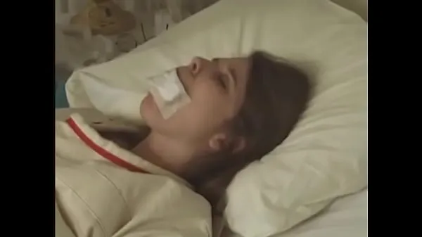 Большая Хорошенькая брюнетка в смирительной рубашке привязана ко рту к постели в больнице теплая трубка