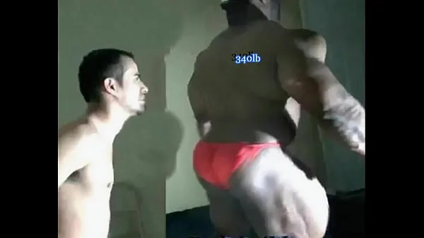 Stort black giant bodybuilder crushing skinny guy varmt rør
